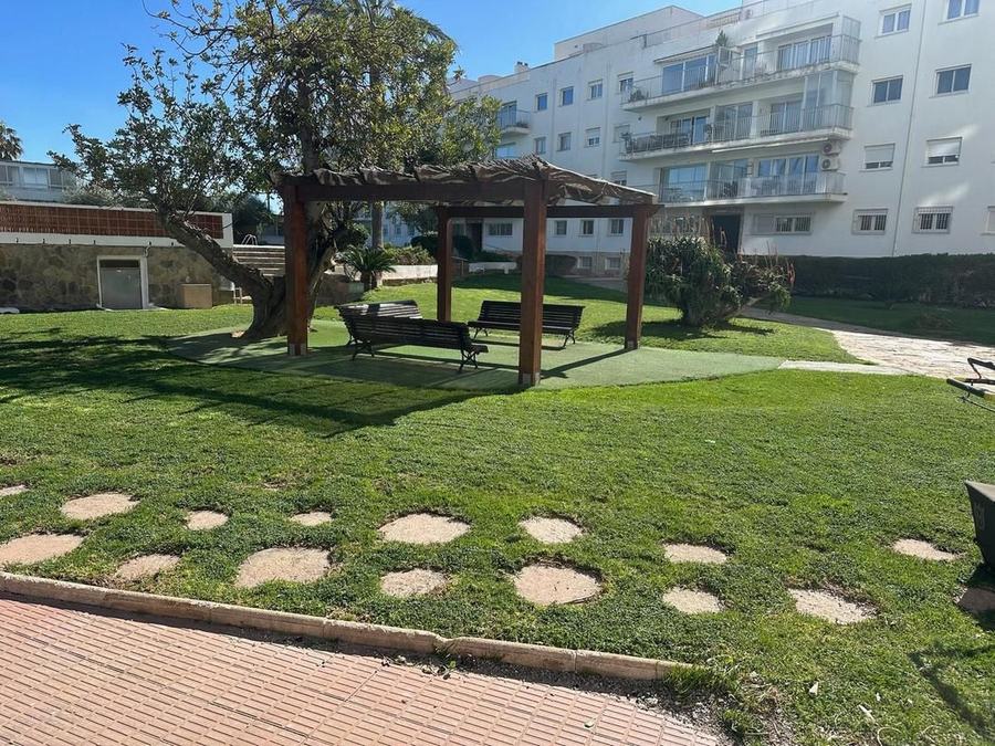 Corte de césped con cortacésped en zona comunitaria